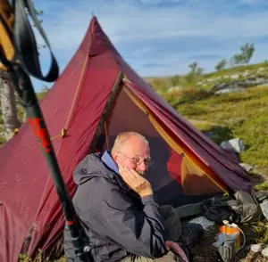 Dirk Nüßer Man sitzt vor dem zelt