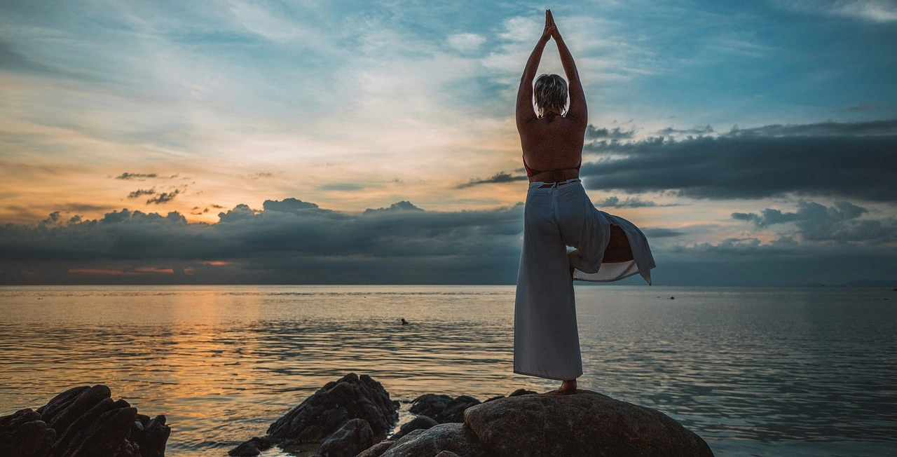 Frau macht Yoga am Meer